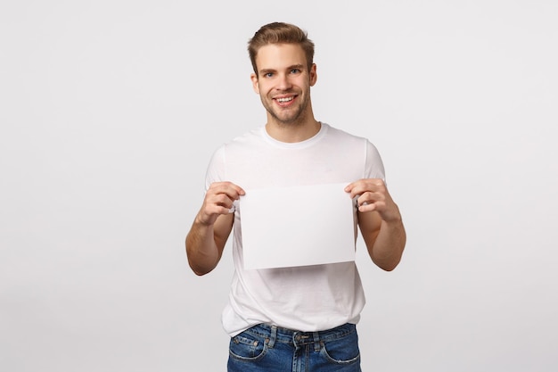 Portrait of smiling young man standing against white background