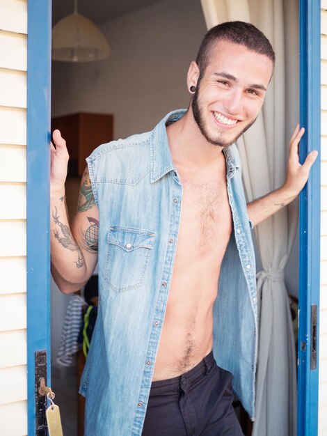 Photo portrait of smiling young man standing amidst sliding door