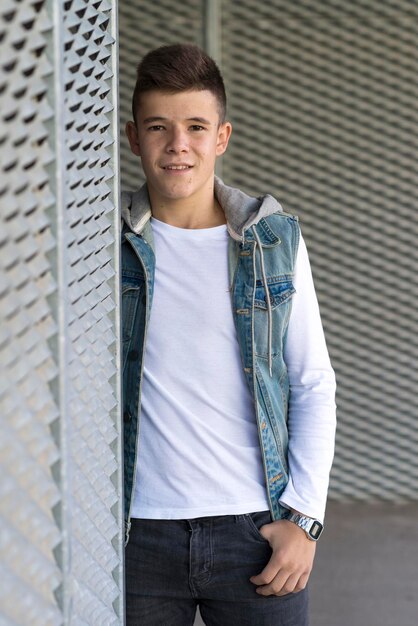 Photo portrait of smiling young man standing by wall outdoors