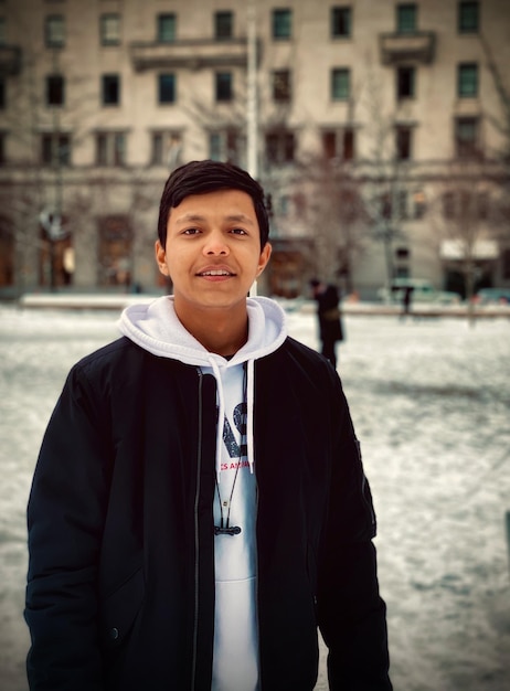 Photo portrait of smiling young man standing outdoors during winter