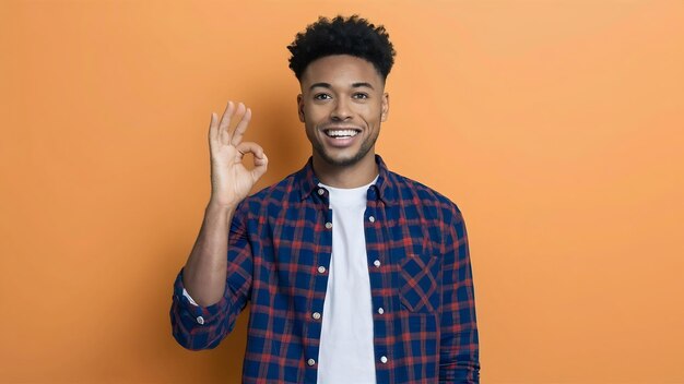 Portrait of a smiling young man standing and showing ok