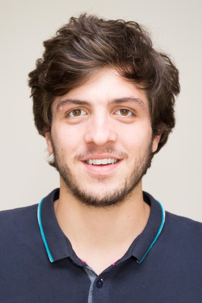 Portrait of smiling young man with beard, on neutral background