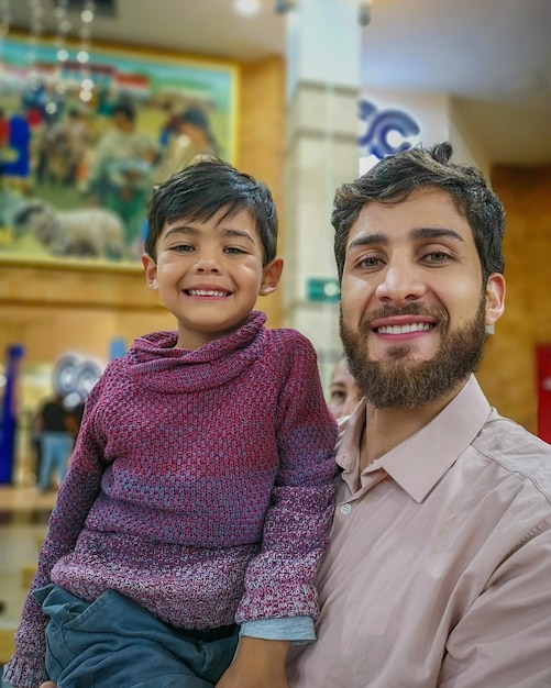 Portrait of smiling young man with son indoors