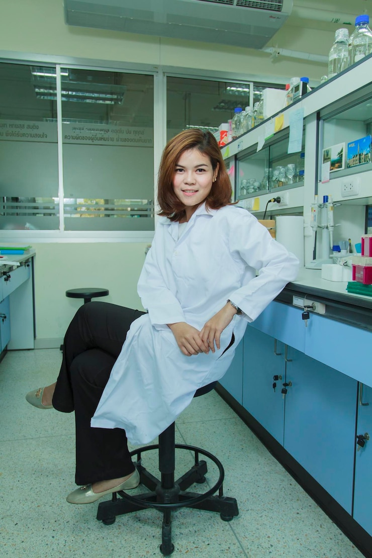 Photo portrait of smiling young scientist sitting at laboratory