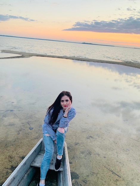 Photo portrait of smiling young sitting on boat at beach