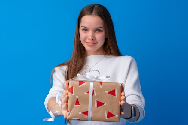 プレゼントボックスを保持している笑顔の若い十代の少女の肖像画