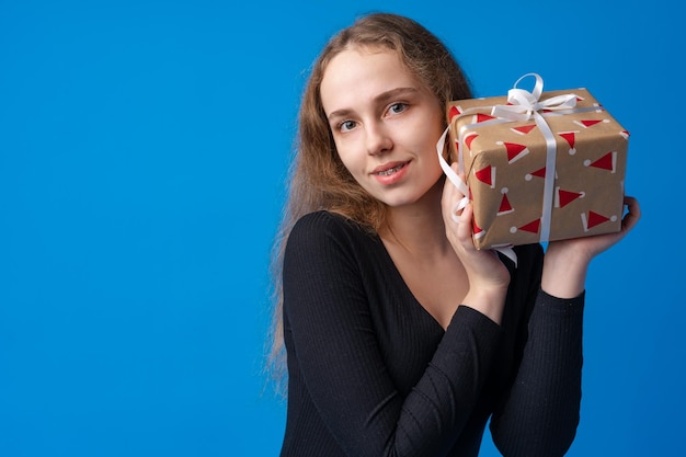 プレゼントボックスを保持している笑顔の若い十代の少女の肖像画