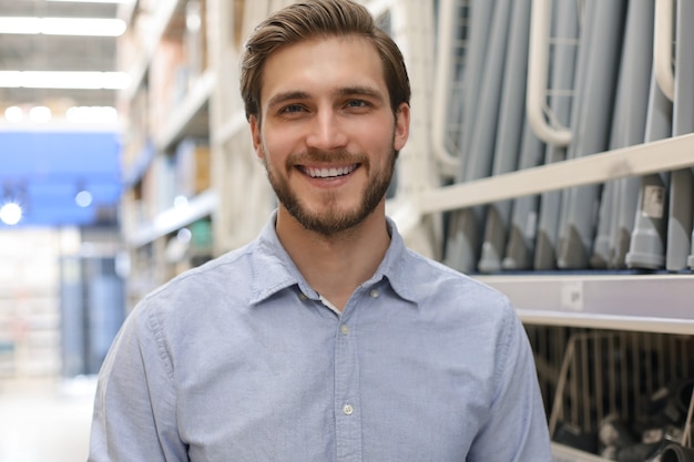 Photo portrait of a smiling young warehouse worker working in a cash and carry wholesale store.