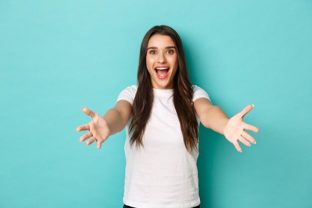 Portrait of smiling young woman against blue background