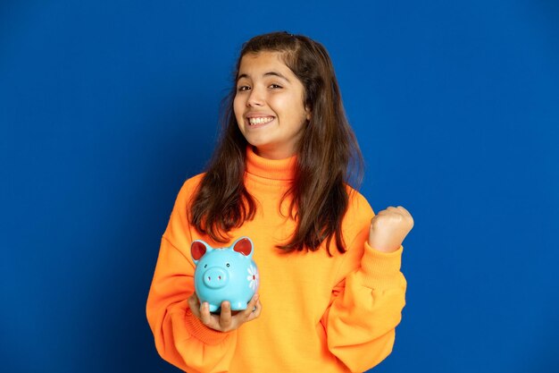 Portrait of a smiling young woman against blue background