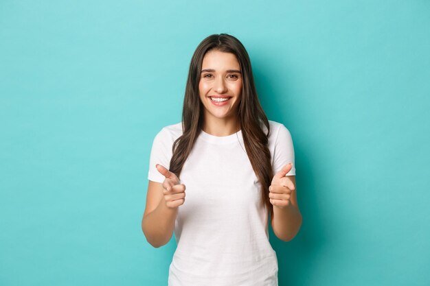 Portrait of smiling young woman against blue background