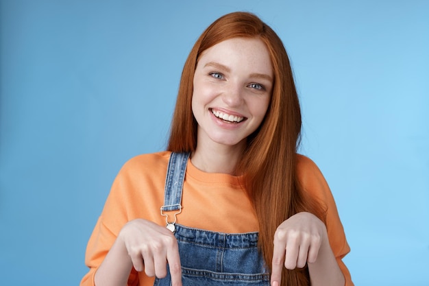 Photo portrait of a smiling young woman against blue background