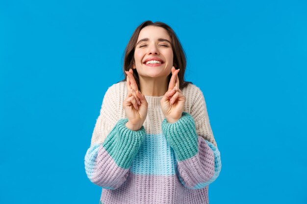 Portrait of a smiling young woman against blue background