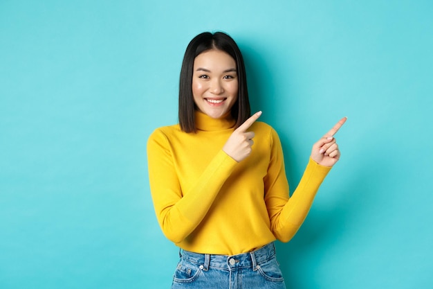 Portrait of a smiling young woman against blue background