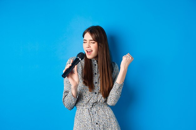 Portrait of a smiling young woman against blue background