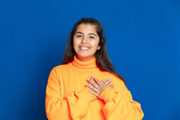 Photo portrait of a smiling young woman against blue background