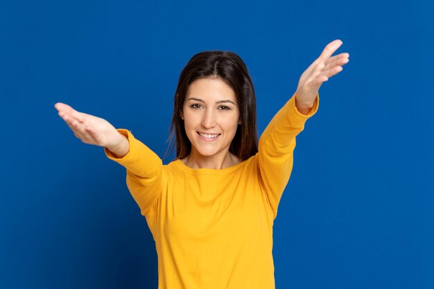 Portrait of a smiling young woman against blue background