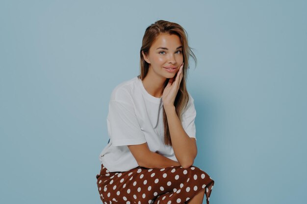 Portrait of smiling young woman against blue background