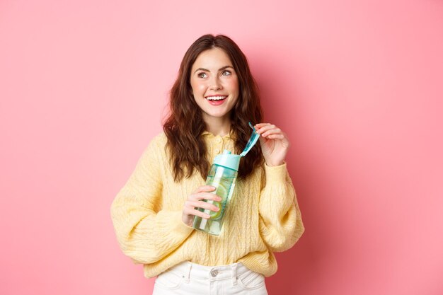 Portrait of a smiling young woman against gray background