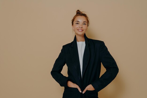 Photo portrait of a smiling young woman against gray background