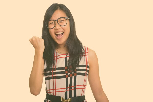 Portrait of smiling young woman against gray background