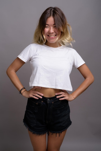 Photo portrait of a smiling young woman against gray background