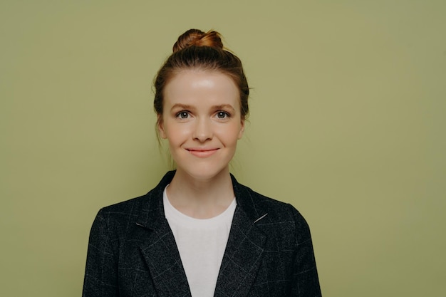 Photo portrait of a smiling young woman against gray background