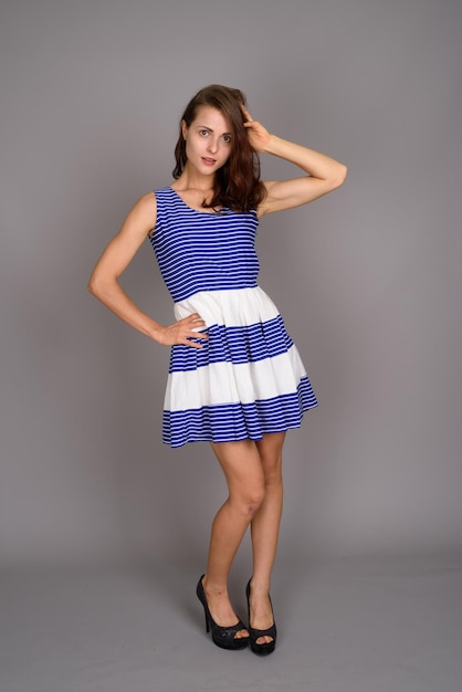 Photo portrait of a smiling young woman against gray background