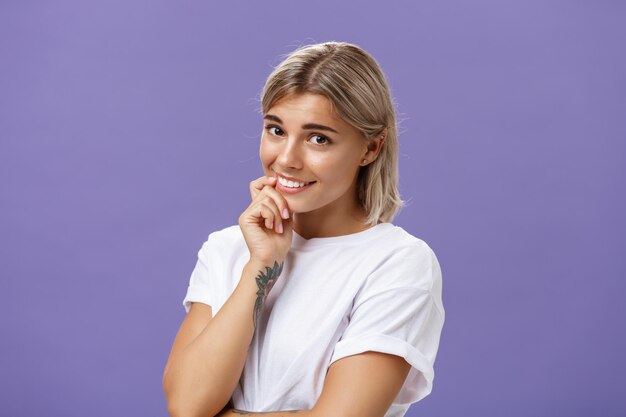 Portrait of smiling young woman against gray background