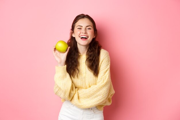 Portrait of a smiling young woman against gray background