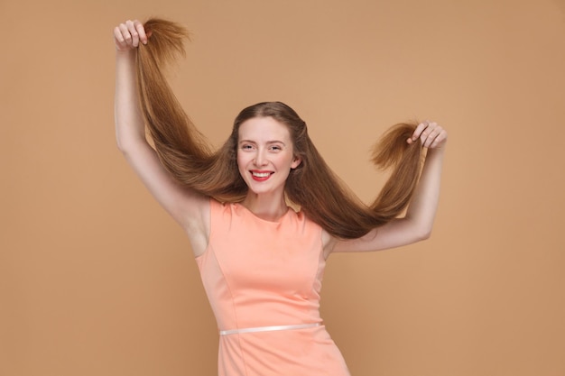 Photo portrait of a smiling young woman against gray background