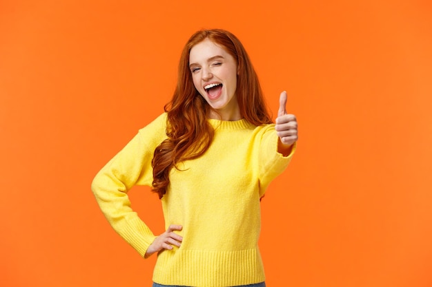 Portrait of smiling young woman against orange background