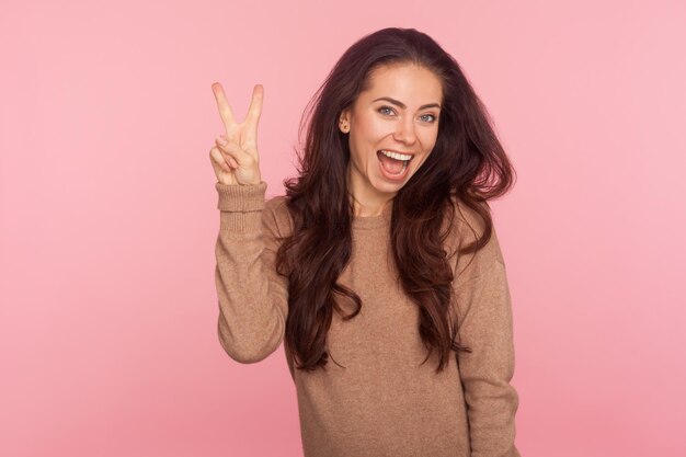 Portrait of smiling young woman against pink background