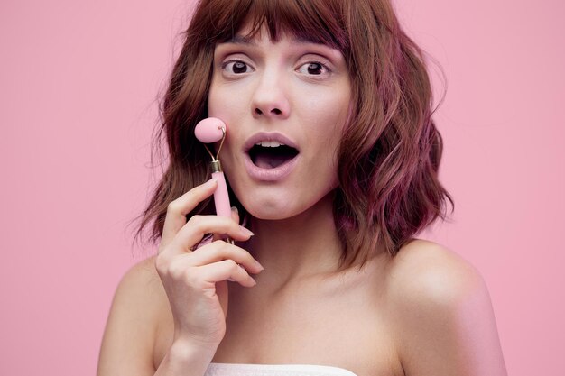 Portrait of smiling young woman against pink background