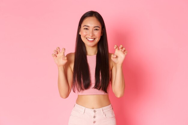 Photo portrait of a smiling young woman against pink background