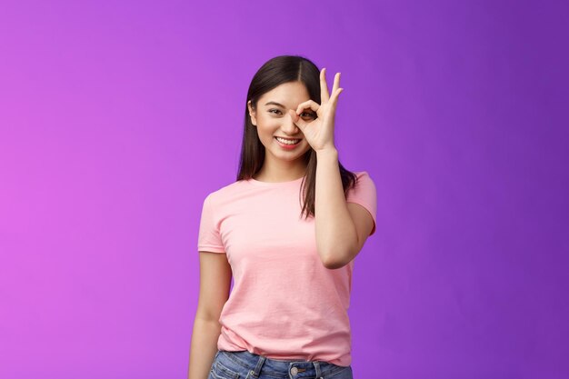 Portrait of smiling young woman against pink background