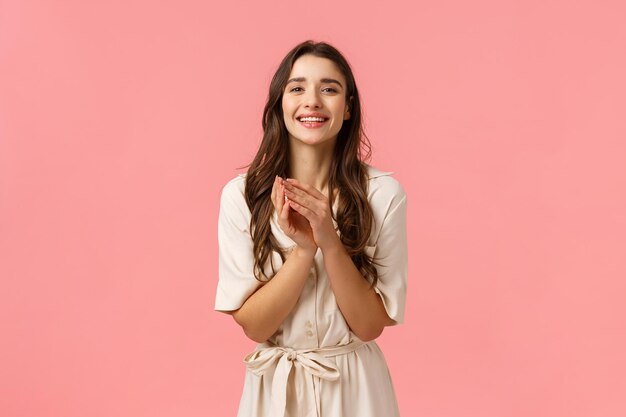 Portrait of a smiling young woman against pink background