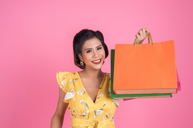 Portrait of a smiling young woman against pink background