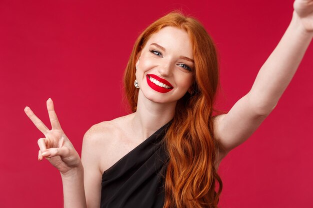 Photo portrait of a smiling young woman against red background