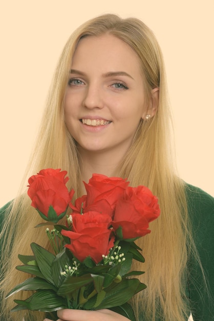 Foto ritratto di una giovane donna sorridente contro la parete rossa
