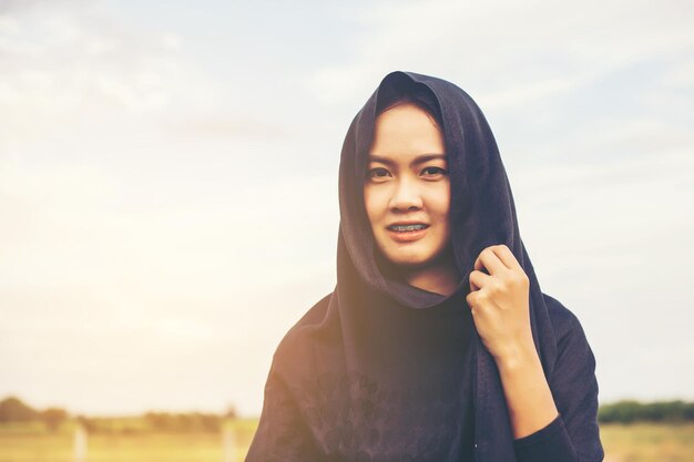 portrait of smiling young woman against sky