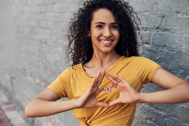 Photo portrait of smiling young woman against wall