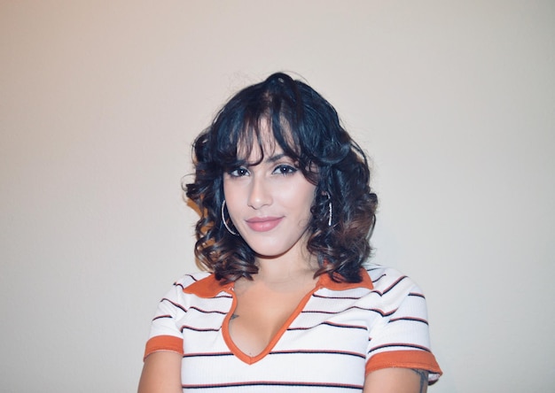 Photo portrait of smiling young woman against wall