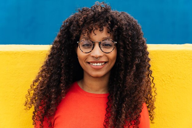 Photo portrait of smiling young woman against wall