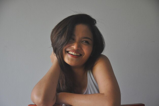 Photo portrait of smiling young woman against white background