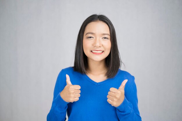 Portrait of smiling young woman against white background