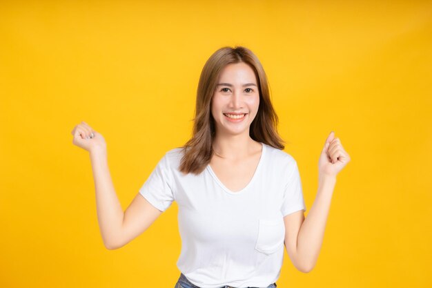 Portrait of a smiling young woman against yellow background