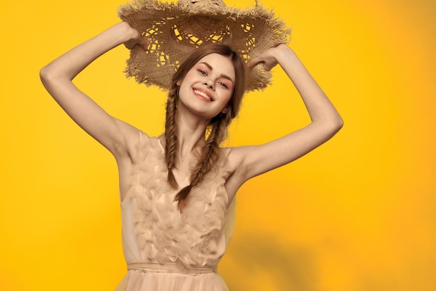 Portrait of smiling young woman against yellow background