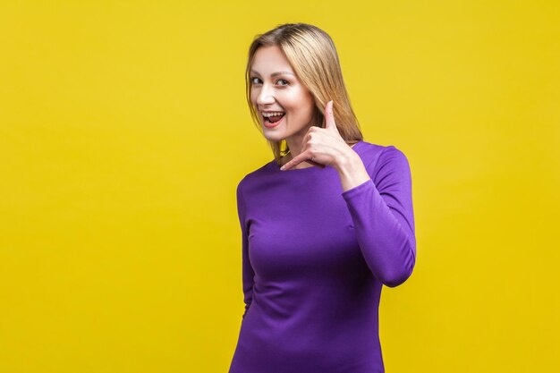 Portrait of a smiling young woman against yellow background