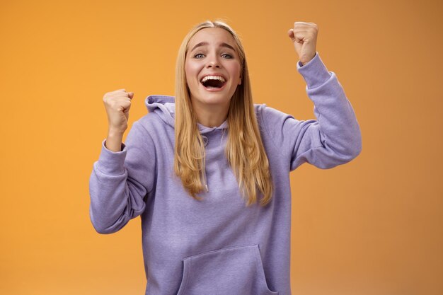 Photo portrait of a smiling young woman against yellow background